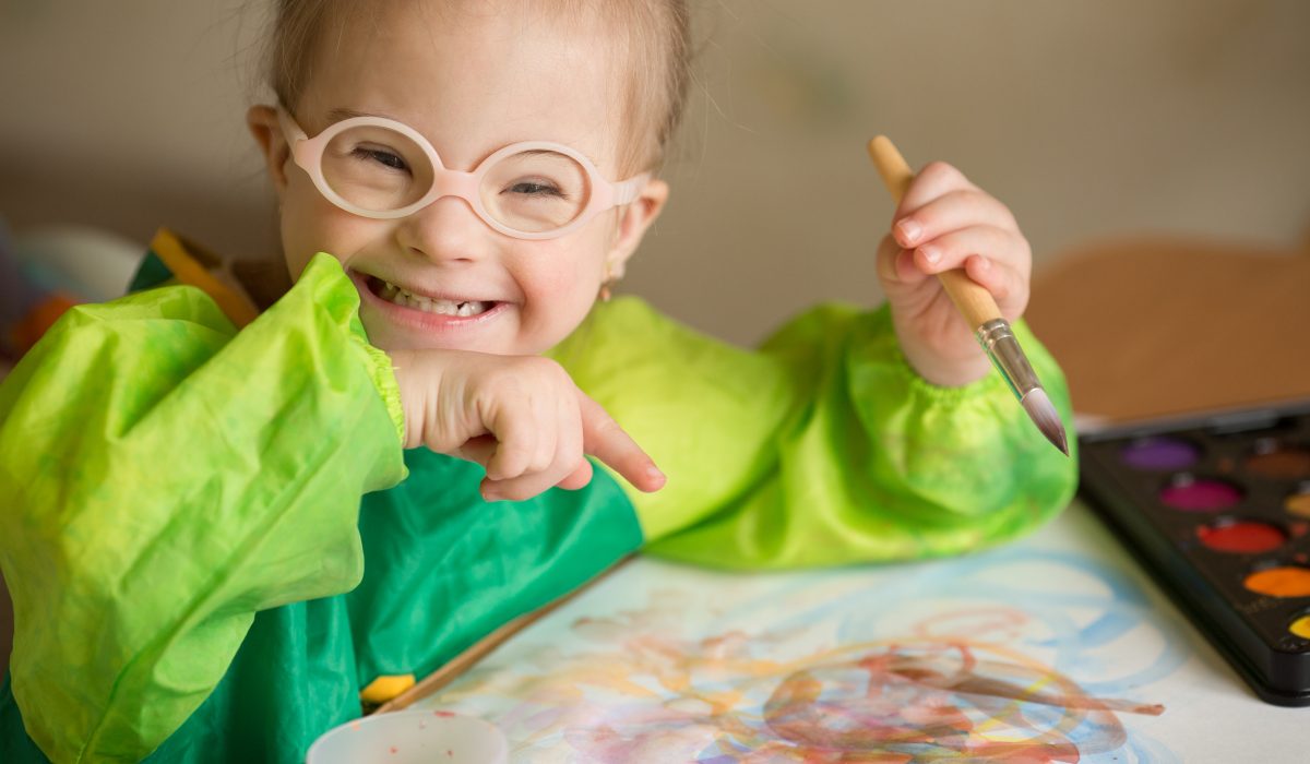 Girl with Down syndrome covered in paint when drawing